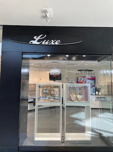 Glass entrance to Luxe Jewelers with jewelry displays inside