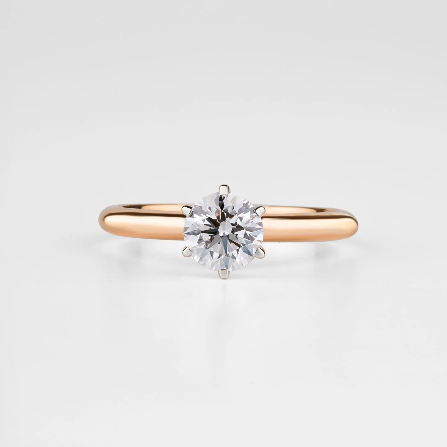 Close photograph of a round diamond solitaire in a polished gold setting